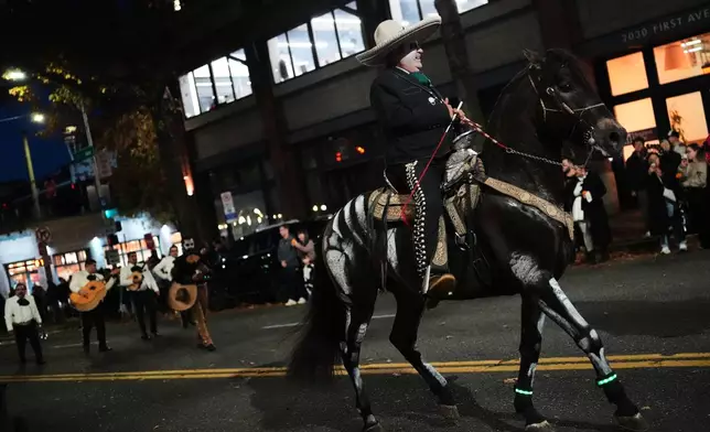 A horse painted to look like a skeleton perform with its rider in a parade during a Día de Muertos celebration at Pike Place Market, Friday, Oct. 23, 2026, in Seattle. (AP Photo/Lindsey Wasson)