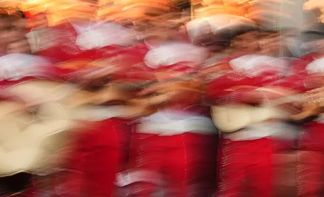 In this slow-shutter speed photo, Eastmont High School Mariachi performs during a Día de Muertos celebration at Pike Place Market, Friday, Oct. 23, 2026, in Seattle. (AP Photo/Lindsey Wasson)