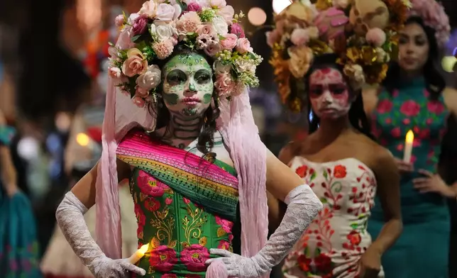 A group of women dressed as Catrinas participate in a parade during a Día de Muertos celebration at Pike Place Market, Friday, Oct. 23, 2026, in Seattle. (AP Photo/Lindsey Wasson)