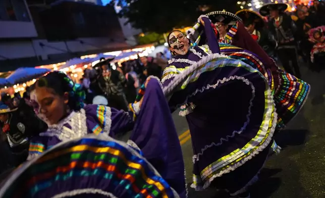 Folk dancers perform in a parade during a Día de Muertos celebration at Pike Place Market, Friday, Oct. 23, 2026, in Seattle. (AP Photo/Lindsey Wasson)