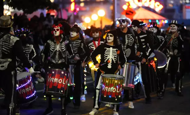 Brazilian drum and dance group VamoLá performs in a parade during a Día de Muertos celebration at Pike Place Market, Friday, Oct. 23, 2026, in Seattle. (AP Photo/Lindsey Wasson)