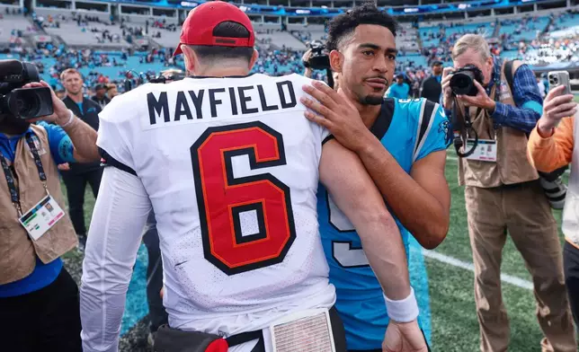 Carolina Panthers quarterback Bryce Young (9), right, hugs Tampa Bay Buccaneers quarterback Baker Mayfield after an NFL football game in Charlotte, N.C., Sunday, Oct. 25, 2026. (AP Photo/Scott Kinser)