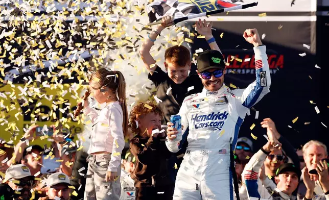 Kyle Larson, top right, celebrates with his chldren Owen, Audrey, and Cooper after his win in a NASCAR Cup Series auto race, Sunday, Oct. 25, 2026, in Talladega, Ala. (AP Photo/Butch Dill)