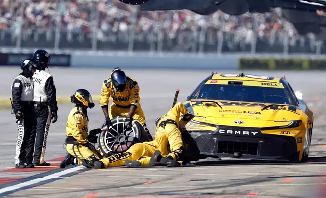 Crew members for Christopher Bell (20) work on his car during a NASCAR Cup Series auto race, Sunday, Oct. 25, 2026, in Talladega, Ala. (AP Photo/Butch Dill)