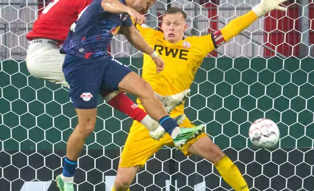 Leipzig's Christoph Baumgartner, foreground, scores a goal past Essen goalkeeper Jakob Golz during the German soccer cup match between Rot Weiss Essen and RB Leipzig in Essen, Germany, Tuesday, Oct. 27, 2026. (Bernd Thissen/dpa via AP)