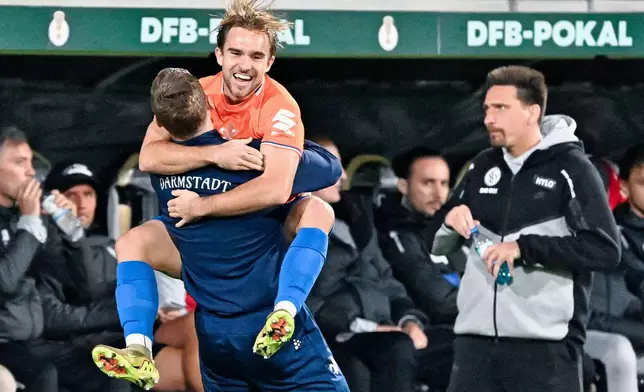 Darmstadt's Lars Kehl, second from left, celebrates with his staff after scoring goal during the German Cup soccer match between SV Elversberg and SV Darmstadt 98, Tuesday, Oct. 26, 2026, in Elversberg, Germany. (Uwe Anspach/dpa via AP)
