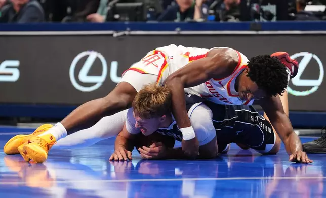 Dallas Mavericks forward Cooper Flagg, bottom, and Houston Rockets' Amen Thompson, top, compete for the ball during the first half of an NBA Cup basketball game in Dallas, Friday, Oct. 30, 2026. (AP Photo/Tony Gutierrez)