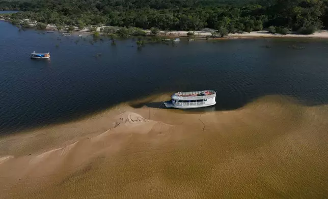 A tourist boat sits idle on sandbanks in the Arapiuns River near the Nova Sociedade community, near Santarem, Para state, Brazil, Thursday, Sept. 3, 2026. (AP Photo/Andre Penner)