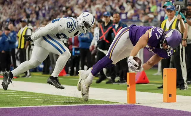 Minnesota Vikings tight end T.J. Hockenson (87) scores past Indianapolis Colts safety A.J. Haulcy (25) during the second half of an NFL football game in Minneapolis, Sunday, Oct. 25, 2026. (AP Photo/Ellen Schmidt)