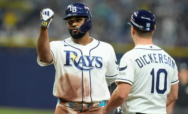 Tampa Bay Rays' Junior Caminero celebrates after hitting a single as first base coach Corey Dickerson (10) watches during the third inning in Game 2 of an American League Division Series baseball game against the New York Yankees Monday, Oct. 5, 2026, in St. Petersburg, Fla. (AP Photo/Chris O'Meara)