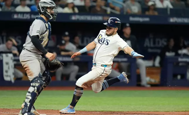 Tampa Bay Rays' Jonathan Aranda, right, scores past New York Yankees catcher Austin Wells during the fifth inning in Game 2 of an American League Division Series baseball game Monday, Oct. 5, 2026, in St. Petersburg, Fla. (AP Photo/Chris O'Meara)