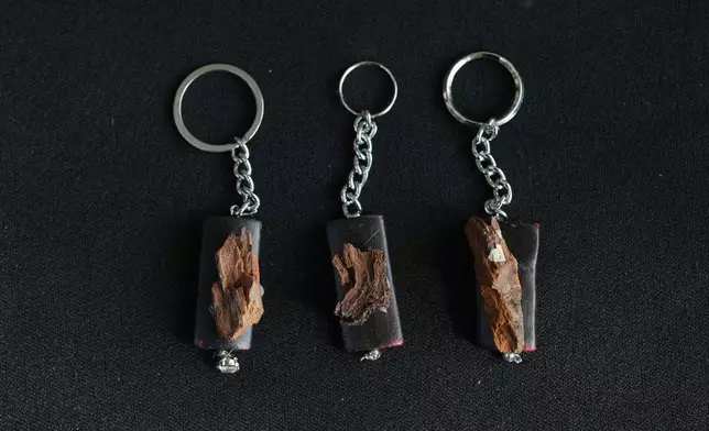 Keychains created by visual artist Lina Jouni using shrapnel collected from Israeli military munitions are displayed at her home in the village of Roumin, southern Lebanon, Saturday, Oct. 24, 2026. (AP Photo/Hassan Ammar)