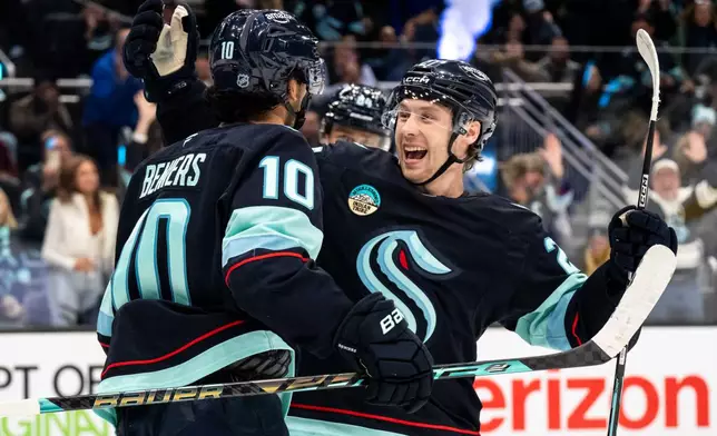 Seattle Kraken forward Berkly Catton, right, and forward Matty Beniers celebrate a goal during the first period of an NHL hockey game against the Utah Mammoth, Thursday, Oct. 22, 2026, in Seattle. (AP Photo/Stephen Brashear)