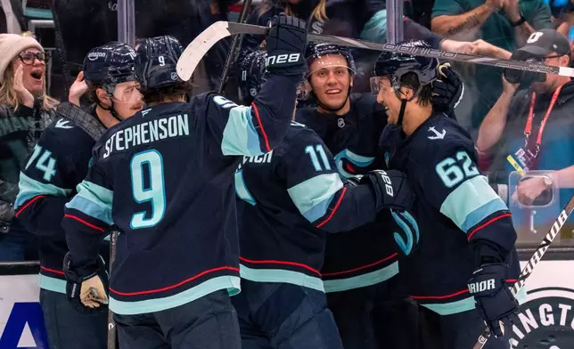 From left, Seattle Kraken, forward Bobby McMann, forward Chandler Stephenson, forward Mackie Samoskevich, defenseman Ryker Evans and defenseman Brandon Montour celebrate a goal during the third period of an NHL hockey game, Thursday, Oct. 22, 2026, in Seattle. (AP Photo/Stephen Brashear)