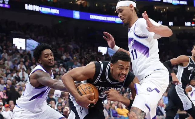 San Antonio Spurs forward Keldon Johnson (3) competes for ball against Utah Jazz forward Brice Sensabaugh, left, and center Jaxson Hayes (11) during the second half of an NBA basketball game, Wednesday, Oct. 28, 2026, in Salt Lake City. (AP Photo/Rob Gray)