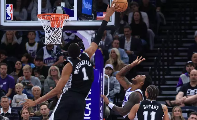San Antonio Spurs forward Victor Wembanyama (1) blocks the shot of Utah Jazz forward Brice Sensabaugh, bottom middle, during the first half of an NBA basketball game, Wednesday, Oct. 28, 2026, in Salt Lake City. (AP Photo/Rob Gray)