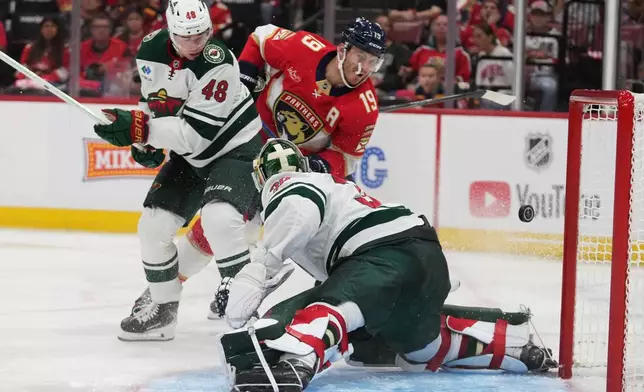 Florida Panthers left wing Matthew Tkachuk (19) scores a goal past Minnesota Wild goaltender Jesper Wallstedt, right, during the second period of an NHL hockey game, Saturday, Oct. 10, 2026, in Sunrise, Fla. (AP Photo/Lynne Sladky)