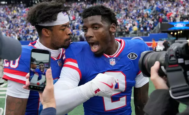 New York Giants cornerback Deonte Banks, right, celebrates his interception returned for a touchdown against the Arizona Cardinals with Giants cornerback Greg Newsome II, left, after an NFL football game, in East Rutherford, N.J., Sunday, Oct. 4, 2026. (AP Photo/Seth Wenig)