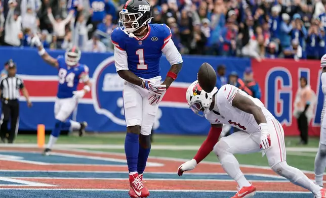 New York Giants wide receiver Malik Nabers (1) celebrates a touchdown catch against Arizona Cardinals linebacker Mack Wilson Sr., right, during an NFL football game, in East Rutherford, N.J., Sunday, Oct. 4, 2026. (AP Photo/Seth Wenig)