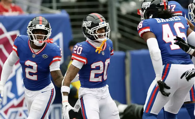 New York Giants cornerback Greg Newsome II (20) celebrates his interception against the Arizona Cardinals with Giants cornerback Deonte Banks (2) and Giants linebacker Zaire Barnes (46) during an NFL football game, in East Rutherford, N.J., Sunday, Oct. 4, 2026. (AP Photo/Adam Hunger)