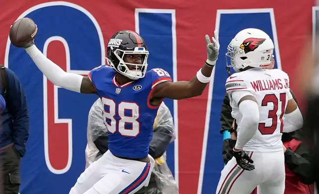 New York Giants wide receiver Malachi Fields (88) celebrates a touchdown catch against Arizona Cardinals safety Wydett Williams Jr. (31) during an NFL football game, in East Rutherford, N.J., Sunday, Oct. 4, 2026. (AP Photo/Seth Wenig)