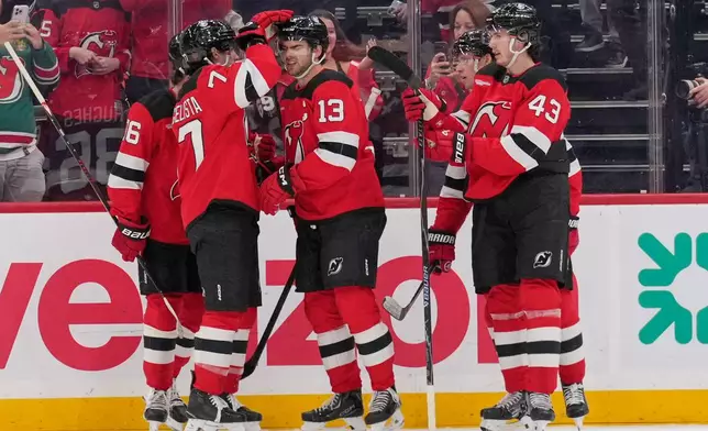 New Jersey Devils' Nico Hischier (13), center, celebrates his goal with teammates during the first period of an NHL hockey game against the Anaheim Ducks in Newark, N.J., Thursday, Oct. 22, 2026. (AP Photo/Seth Wenig)