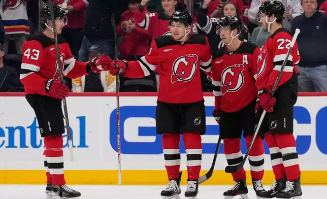 New Jersey Devils' Arseny Gritsyuk, second from left, celebrates his goal with teammates during the first period of an NHL hockey game against the Anaheim Ducks in Newark, N.J., Thursday, Oct. 22, 2026. (AP Photo/Seth Wenig)