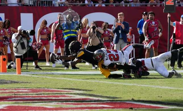 Pittsburgh Steelers wide receiver Germie Bernard (17) stretches to score a touchdown as Tampa Bay Buccaneers cornerback Zyon McCollum (27) attempts to tackle during overtime at an NFL football game in Tampa, Fla., Sunday, Oct. 18, 2026. (AP Photo/Chris O'Meara)