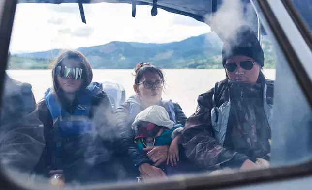 The Woods family travels by boat along the Yukon River from Rampart, Alaska, toward Fairbanks, Monday, July 13, 2026. (AP Photo/Annika Hammerschlag)