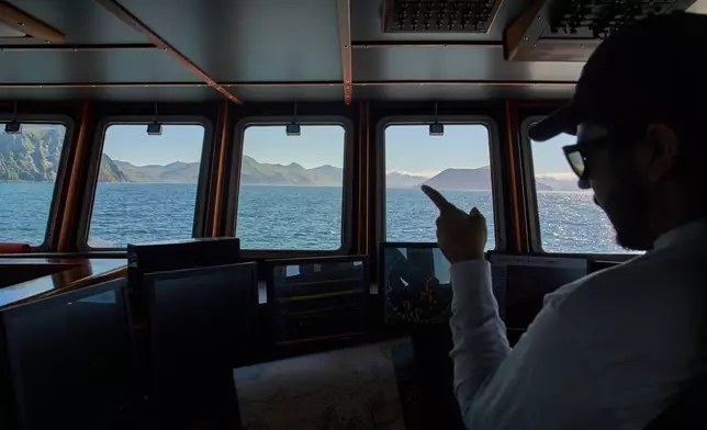 Maverick Blake, captain of the F/V Progress, monitors screens in the wheelhouse that help track fishing conditions in the Bering Sea off the coast of Alaska, Friday, July 24, 2026. (AP Photo/Annika Hammerschlag)