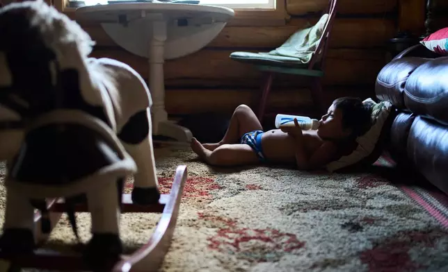 Lewis Thomas watches TV at his home in Rampart, Alaska, Saturday, July 11, 2026. (AP Photo/Annika Hammerschlag)