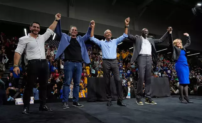 Former President Barack Obama, center, joined by Democratic nominee for U.S. Senate Abdul El-Sayed, left, and Democratic gubernatorial nominee and Michigan Secretary of State Jocelyn Benson, right with Secretary of State nominee, Lt. Gov. Garlin Gilchrist, second from right and Attorney General nominee Eli Savit, second from left, clasp hands after a campaign event at Cass Technical High School Saturday, Oct. 24, 2026, in Detroit.(AP Photo/Paul Sancya)