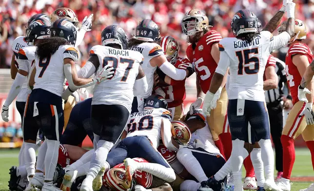 Denver Broncos players react after stopping San Francisco 49ers quarterback Brock Purdy, middle right, on fourth down to turn the ball over on downs during the first half of NFL football game in Santa Clara, Calif., Sunday, Oct. 4, 2026. (AP Photo/Kelley L. Cox)
