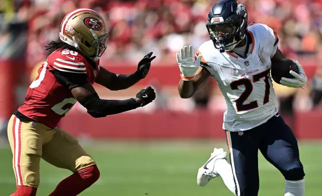 Denver Broncos running back J.K. Dobbins (27) runs against San Francisco 49ers cornerback Upton Stout during the first half of an NFL football game in Santa Clara, Calif., Sunday, Oct. 4, 2026. (AP Photo/Justine Willard)
