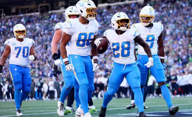 Los Angeles Chargers running back Kimani Vidal (28) celebrates after scoring a touchdown during the second half of an NFL football game against the Seattle Seahawks, Sunday, Oct. 4, 2026, in Seattle. (AP Photo/Kevin Ng)