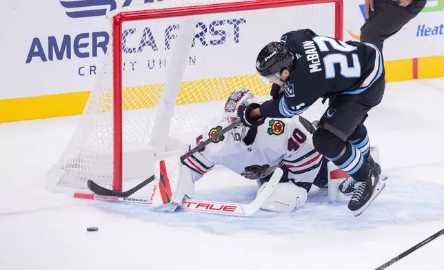 Utah Mammoth center Jack McBain (22) fights for the puck against Chicago Blackhawks goalie Arvid Soderblom (40) during the second period of an NHL hockey game Thursday, Oct. 1, 2026, in Salt Lake City. (AP Photo/Melissa Majchrzak)