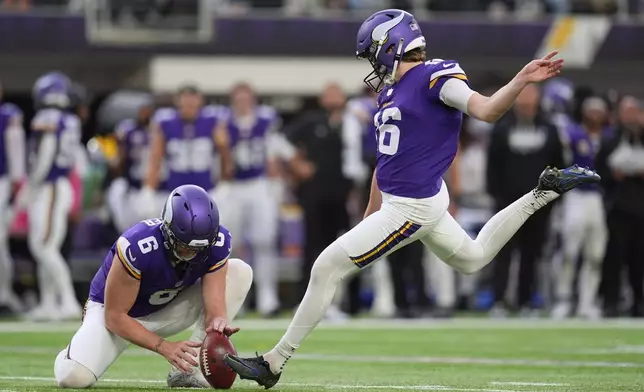 Minnesota Vikings kicker Will Reichard, right, with Dwight McGlothern Jr. holding, kicks a field goal against the Miami Dolphins during the second half of an NFL football game Sunday, Oct. 4, 2026, in Minneapolis. (AP Photo/Abbie Parr)