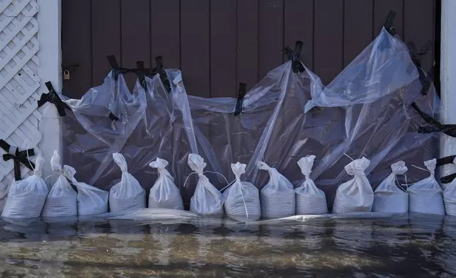 Sandbags are placed outside a home to protect it from floodwaters in Huntington Beach, Calif., Wednesday, Oct. 28, 2026. (AP Photo/Jae C. Hong)