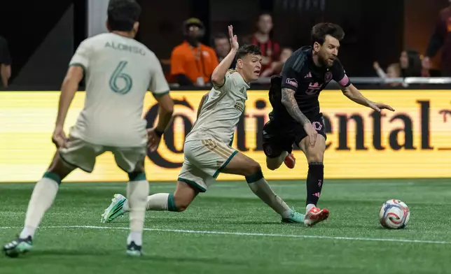 Atlanta United defender Elías Báez, second from right, fouls Inter Miami forward Lionel Messi, right, during the first half of an MLS soccer match Saturday, Oct. 17, 2026, in Atlanta. (AP Photo/Vasha Hunt)