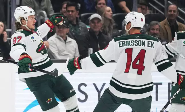 Minnesota Wild left wing Kirill Kaprizov (97) celebrates scoring against the Seattle Kraken with center Joel Eriksson Ek (14) during the first period of an NHL hockey game Saturday, Oct. 24, 2026, in Seattle. (AP Photo/Lindsey Wasson)