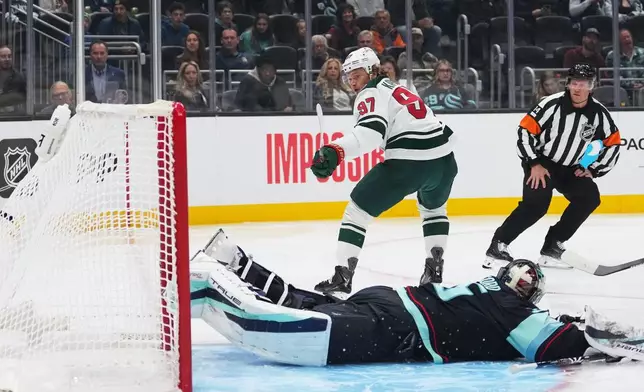 Minnesota Wild left wing Kirill Kaprizov (97) scores a goal against Seattle Kraken goaltender Joey Daccord (35) during the first period of an NHL hockey game Saturday, Oct. 24, 2026, in Seattle. (AP Photo/Lindsey Wasson)