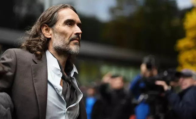 Russell Brand arrives at Southwark Crown Court, London, Tuesday, Oct. 27, 2026, where he faces three charges of rape, indecent assault, and three counts of sexual assault, relating to six women. (Jordan Pettitt/PA via AP)