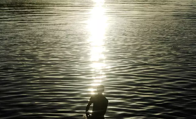 A man bathes in the morning in the Suriname River in Nieuw Aurora, Suriname, Monday, Sept. 28, 2026. (AP Photo/Ivan Valencia)