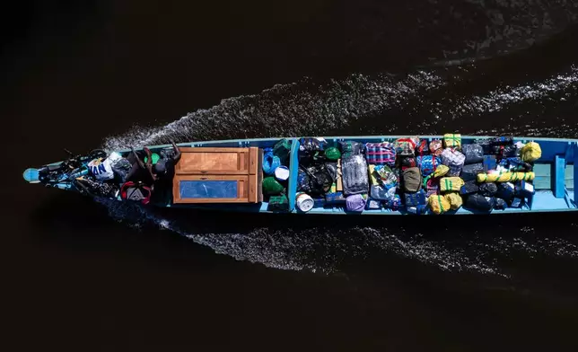 A boat transports personal items in Saamaka territory near Nieuw Aurora, Suriname, Wednesday, Sept. 30, 2026. (AP Photo/Ivan Valencia)