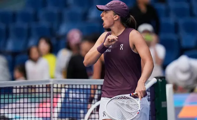 Iga Swiatek, of Poland celebrates after winning the match against Iva Jovic, of the United States, during the fourth round of the women's singles match at the China Open tennis tournament in Beijing, Wednesday, Oct. 7, 2026. (AP Photo/Andy Wong)