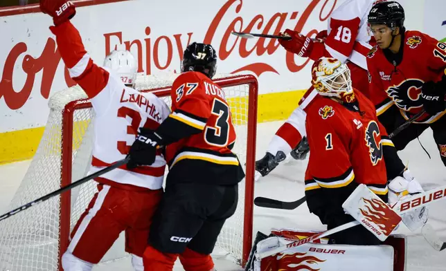 Detroit Red Wings' J.T. Compher (37) celebrates a goal by teammate Andrew Copp (18) as Calgary Flames goalie Devin Cooley (1) reacts during second period NHL hockey action in Calgary, Alberta, Saturday, Oct. 24, 2026. (Jeff McIntosh/The Canadian Press via AP)