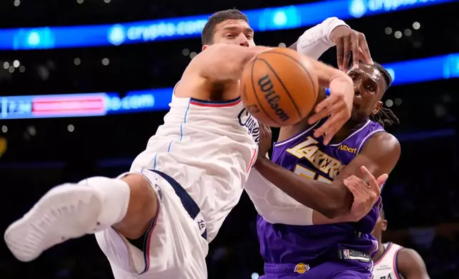 LA Clippers center Brook Lopez, left, and Los Angeles Lakers forward Kevon Looney grapple for the ball during the first half of an NBA basketball game Friday, Oct. 23, 2026, in Los Angeles. (AP Photo/Mark J. Terrill)