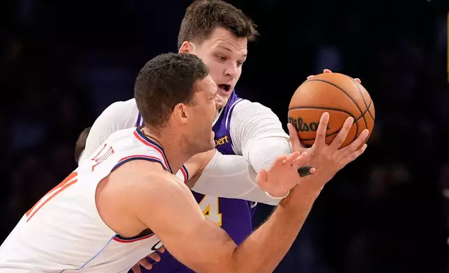 LA Clippers center Brook Lopez, left, tries to shoot as Los Angeles Lakers center Walker Kessler defends during the first half of an NBA basketball game Friday, Oct. 23, 2026, in Los Angeles. (AP Photo/Mark J. Terrill)