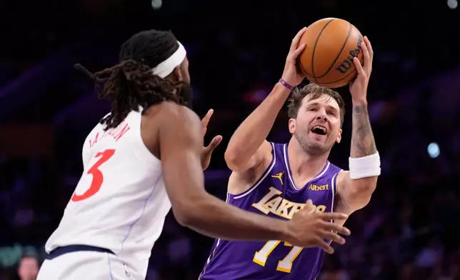 Los Angeles Lakers guard Luka Doncic, right, shoots as LA Clippers forward Isaiah Jackson defends during the first half of an NBA basketball game Friday, Oct 23, 2026, in Los Angeles. (AP Photo/Mark J. Terrill)