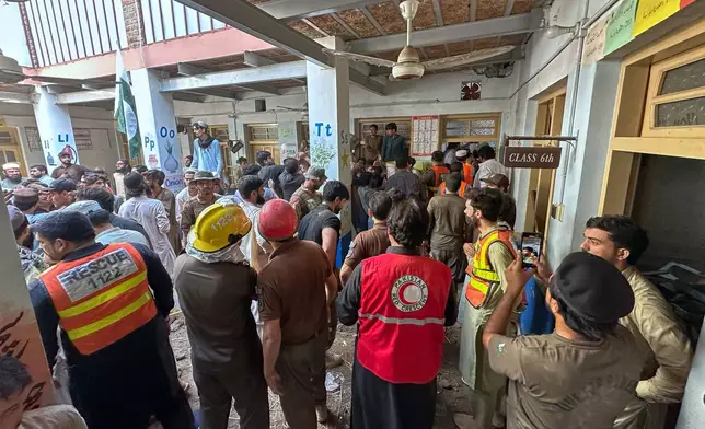 Rescue workers and volunteers take part in the rescue operation at the site of a roof collapse at a private school, in Peshawar, Pakistan, Thursday, Oct. 15, 2026. (AP Photo/Maaz Awan)